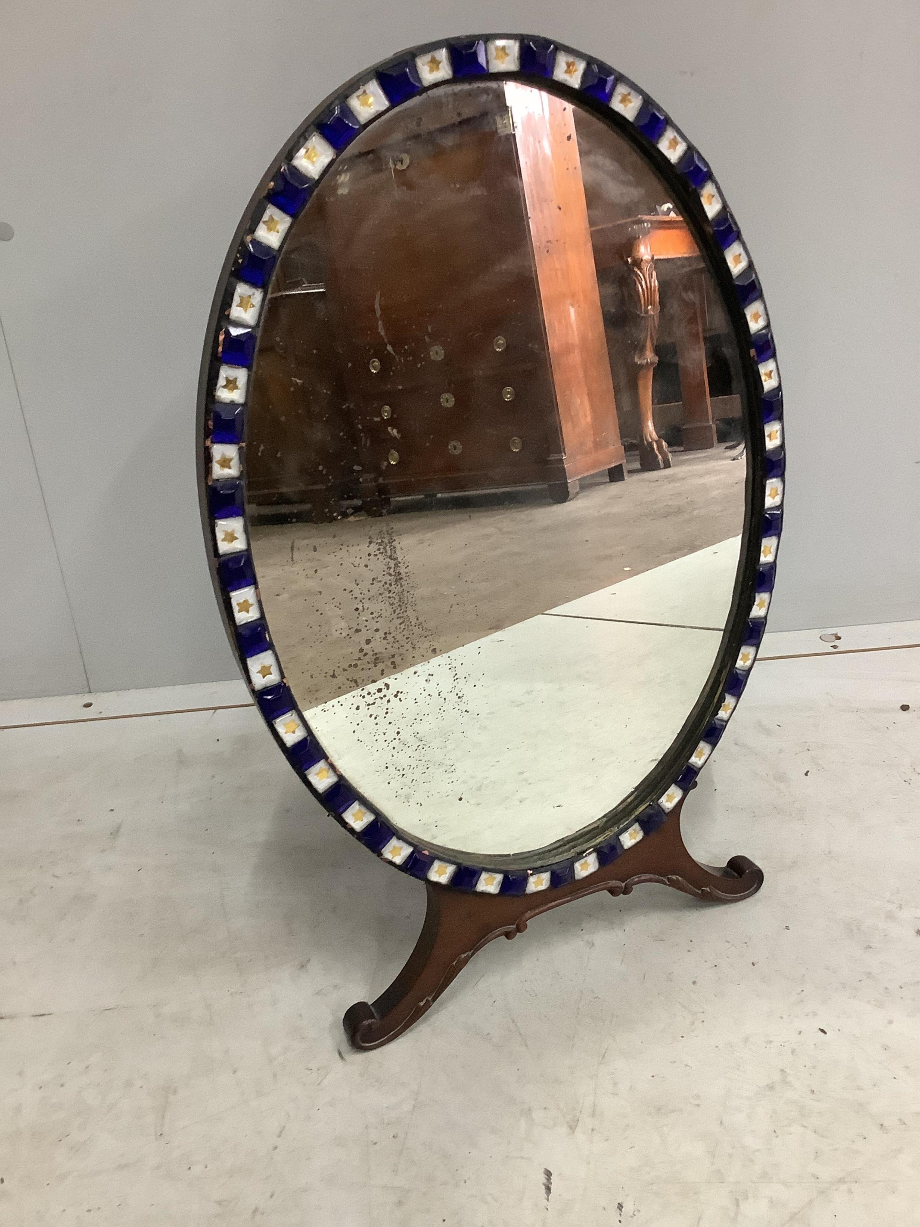 An early 20th century Irish glass bead applied mahogany toilet mirror, modelled in the 18th century manner and with label for M Butler of Dublin, width 40cm, height 62cm. Condition - fair